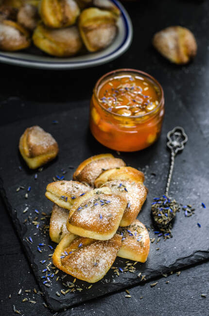 Curd cookies and apricot jam with lavender served on slate surface — Stock Photo