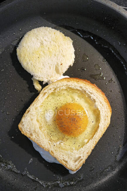 Un huevo en un nido (huevo frito en tostadas) - foto de stock