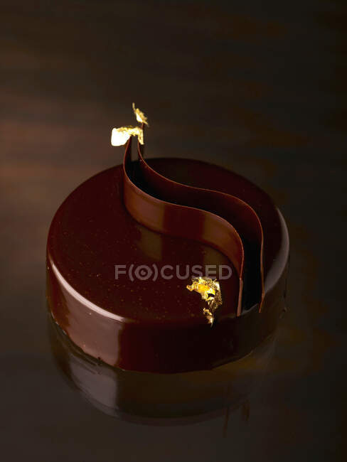 Pastel de chocolate festivo con detalles de hoja de oro - foto de stock