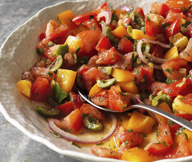 Томатный салат с перцем, оливками и красным луком (крупным планом)) — стоковое фото