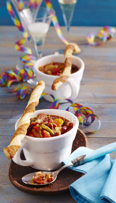Spicy bean soup with sausages served with yeast dough and puff pastry Parmesan sticks — Stock Photo
