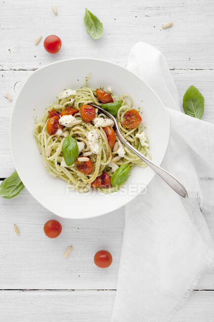 Nudeln mit Tomaten, Mozzarella, Pinienkernen und Basilikum — Stockfoto