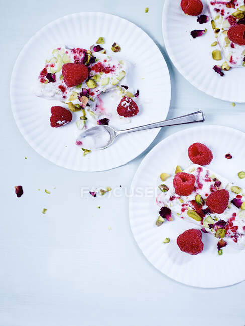 Cream with pistachios and raspberries on plates — Stock Photo