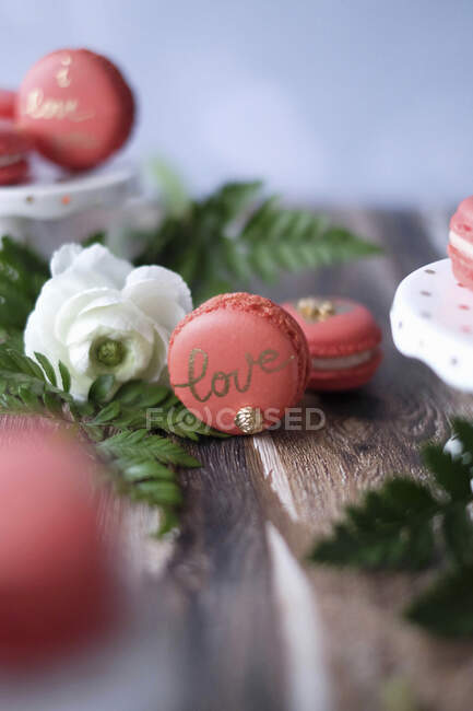 Macarons vermelhos com letras de amor e flores — Fotografia de Stock