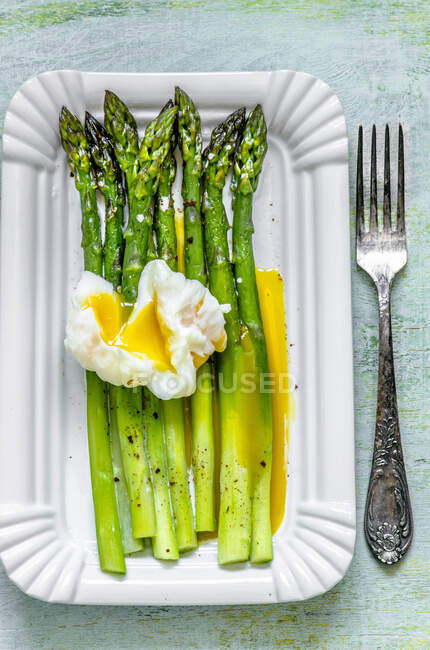 Espárragos con huevo escalfado y salsa verde - foto de stock