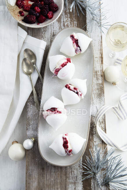 Meringhe con ripieno di crema di bacche su piatto lungo — Foto stock