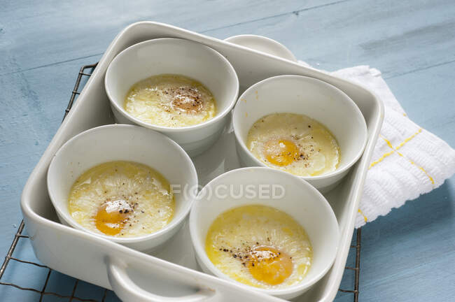 Baked eggs with pepper in ramekins in tin — Stock Photo