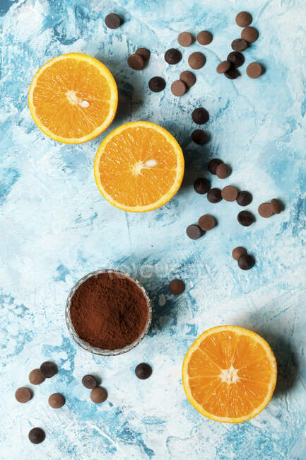 Mitades de naranjas con chispas de chocolate y cacao en polvo - foto de stock