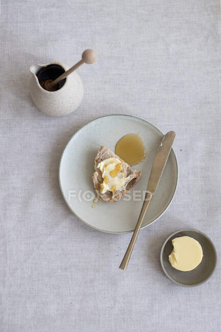 Close-up shot of delicious slice of bread with butter and honey — Stock Photo