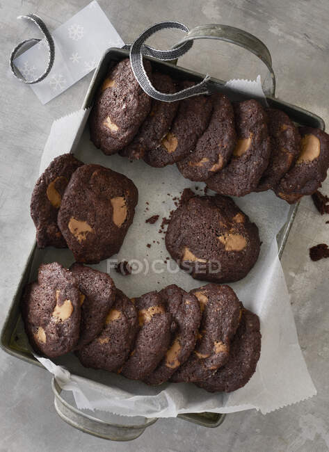 Chocolate biscuits in metal tray with ribbon — Stock Photo