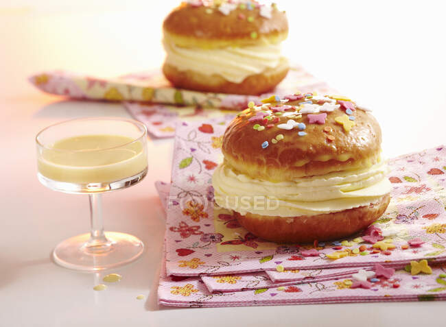 Un donut de carnaval glaseado lleno de crema de ponche de huevo - foto de stock