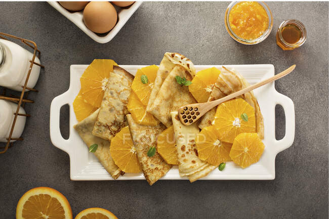 Crepes suzette with cream cheese filling, orange sauce and fresh oranges — Stock Photo