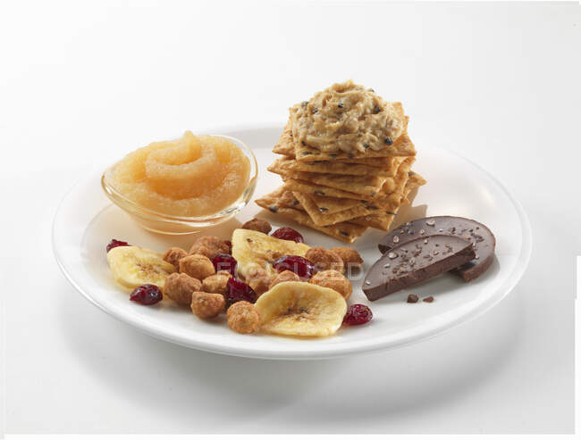 Snacks: Cracker mit Thunfischcreme, Apfelmus, Trail Mix und Schokolade — Stockfoto