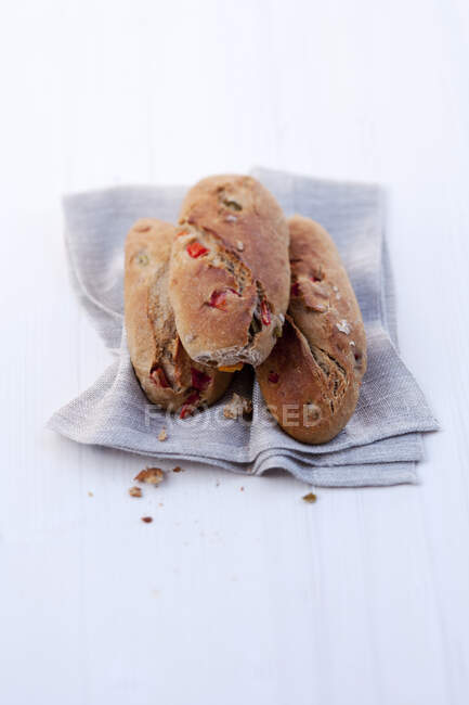 Rolos de pão com pimentas em guardanapo de pano — Fotografia de Stock