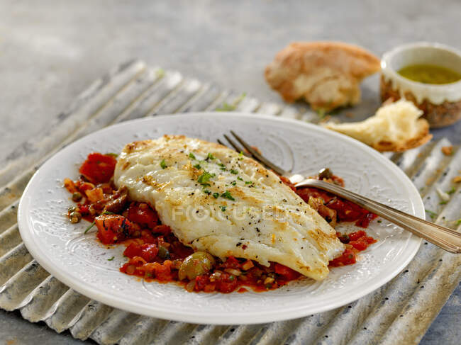 Cod fillets on tomato and olive salsa — Stock Photo