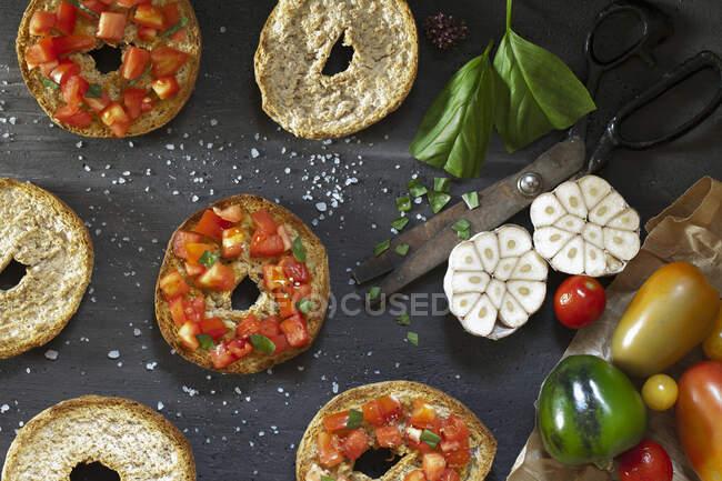 Vista superior de la mesa con bruschetta italiana sobre pan frisella, sazonado con tomates frescos, ajo, aceite de oliva, sal y albahaca - foto de stock
