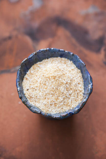 Roasted grated coconut in a blue ceramic bowl — Stock Photo