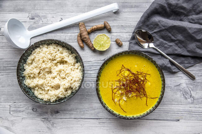 Turmeric soup with rice and chili strings — Stock Photo