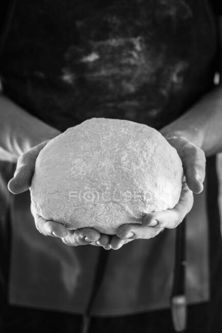 Mains tenant une boule de pâte — Photo de stock