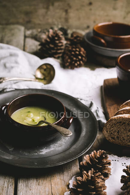 Zucchini soup on a wintery, rustic wooden table — Stock Photo