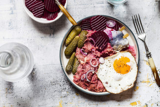 Lobscouse con aringhe saltate, uova fritte, barbabietole e cetriolini — Foto stock