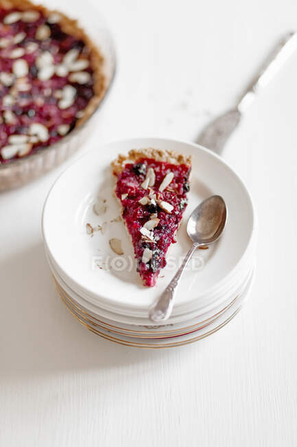 A slice of berry tart with flaked almonds — Stock Photo
