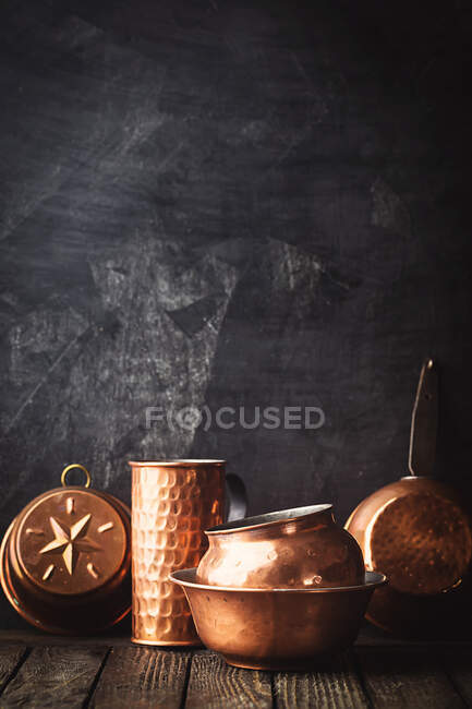 Verschiedene Arten von Vintage-Kupfer-Kochgeschirr vor dunklem Hintergrund — Stockfoto