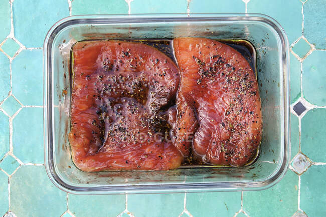Marinated turkey steaks in glass pan — Stock Photo