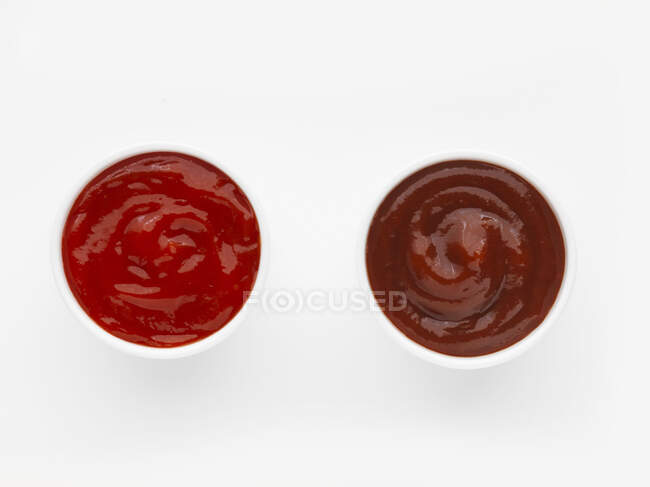 Zwei Schalen Ketchup vor weißem Hintergrund (Draufsicht)) — Stockfoto
