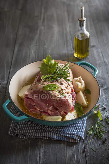 Schweineschulter mit schwarzem Pfeffer, frischen Kräutern, Knoblauch, Zwiebeln und Oliven fertig gebraten — Stockfoto