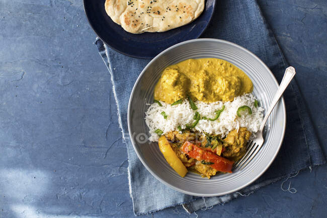 Chicken jalfrezi and chicken korma with rice and naan bread — Stock Photo