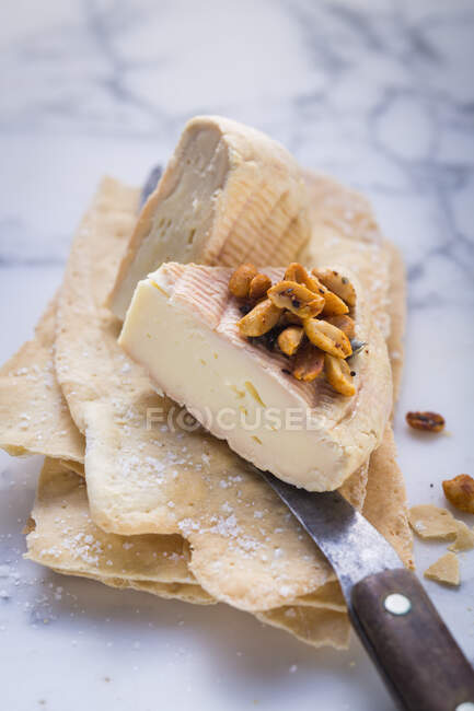 Два шматки сиру з арахісом на тонкому пласкій хлібі — стокове фото
