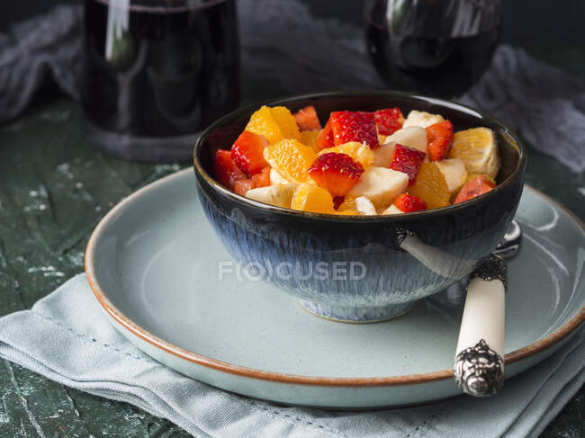 Salada de macedônia com morangos, laranjas e banana com suco de limão, açúcar mascavo e licor de laranja — Fotografia de Stock