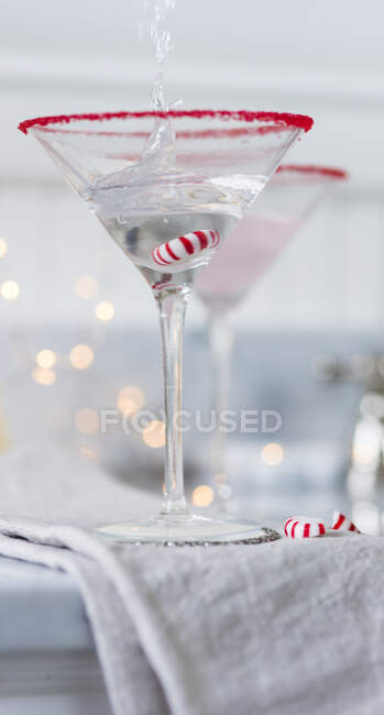 Выпивка, наливаемая в бокал мартини на рождественский бонбон — стоковое фото