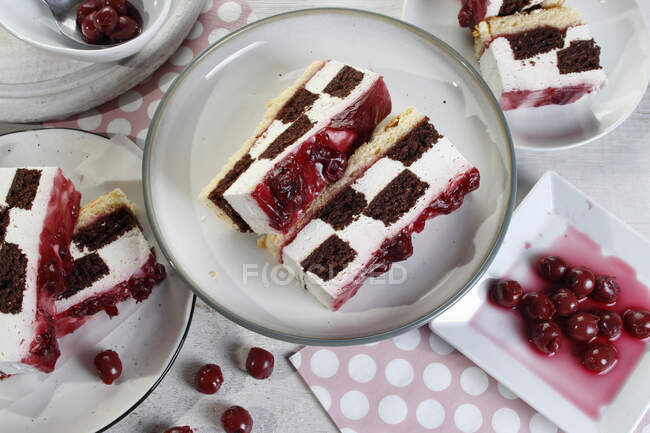Checkerboard cake with cherries — Stock Photo