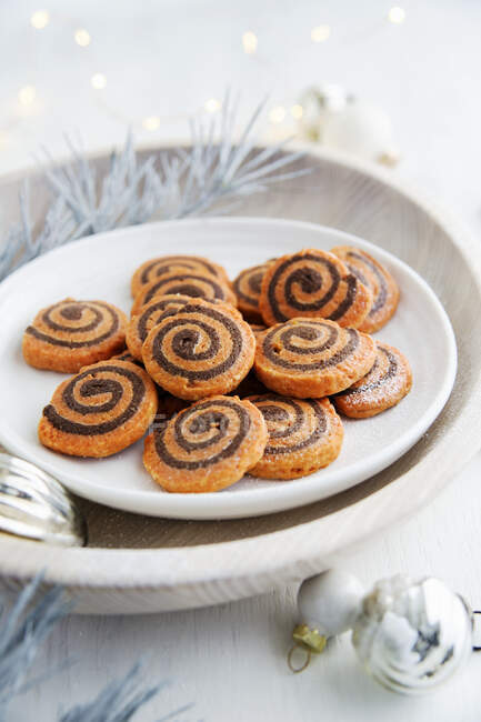 Swirls cookies on white plate in wooden bowl with decorations — Foto stock