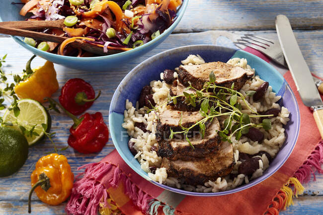 Jerk pork with Jamaican rice and salad in bowls — Stock Photo