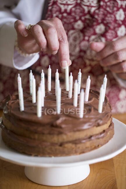 A birthday cake being decorated with candles — Stock Photo