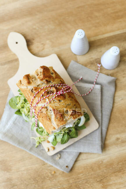 Courgettes et sandwich à la laitue d'agneau sur planche de bois — Photo de stock