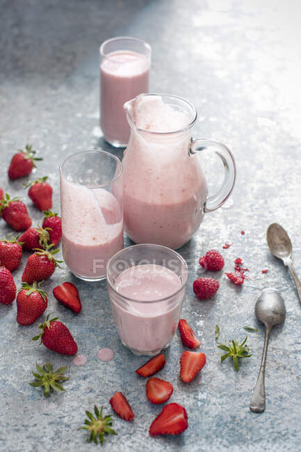 Morangos e framboesas bebendo iogurte em copos e jarro — Fotografia de Stock