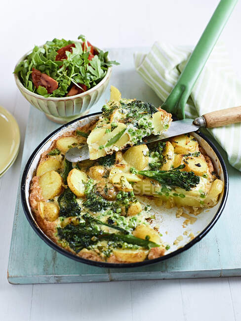 Фріттата з картоплею та брокколі та салатом у мисці — стокове фото