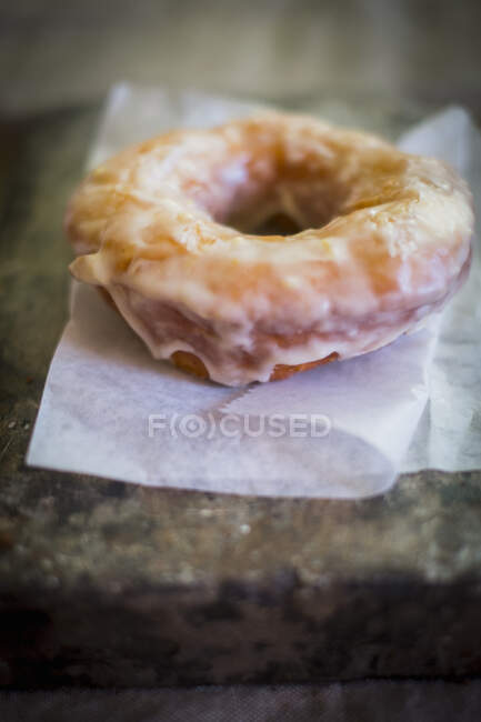 Um donut de limão no papel — Fotografia de Stock
