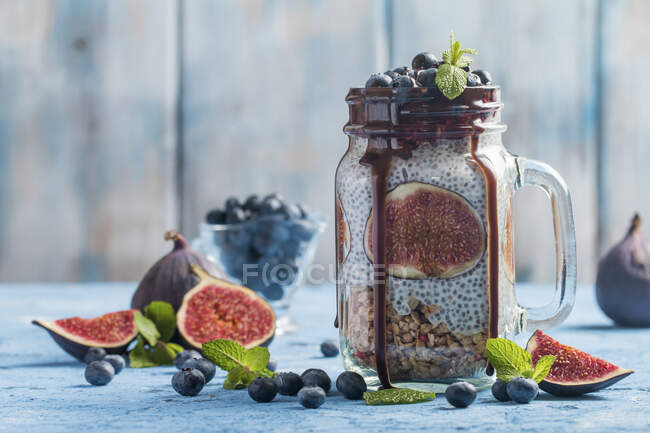 Frasco de vidro de café da manhã saudável com muesli, pudim com sementes de chia, figo fresco e bagas — Fotografia de Stock
