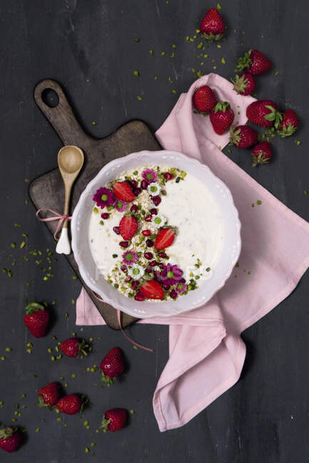 Tazón de yogur con avena integral, fresas, pistachos y granada - foto de stock