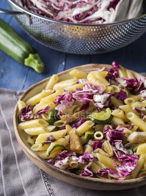 Pennette Pasta mit rotem Chicorée, Zucchini und gegrilltem Huhn in rustikaler Schüssel — Stockfoto