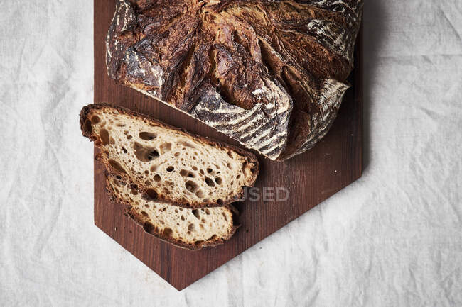 Pan de granja sobre tabla de cortar de madera - foto de stock