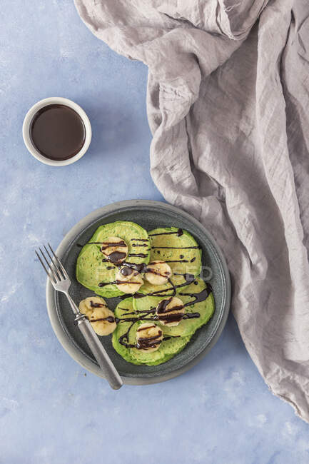 Green pancakes with banana and chocolate sauce — Photo de stock