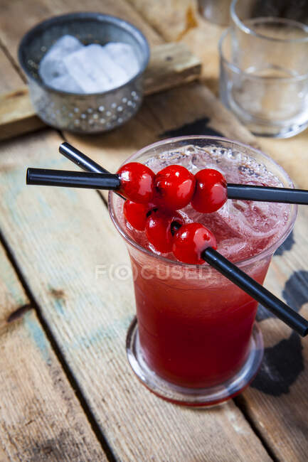 Singapore Sling with cherry liqueur and cherries on straws — Stock Photo