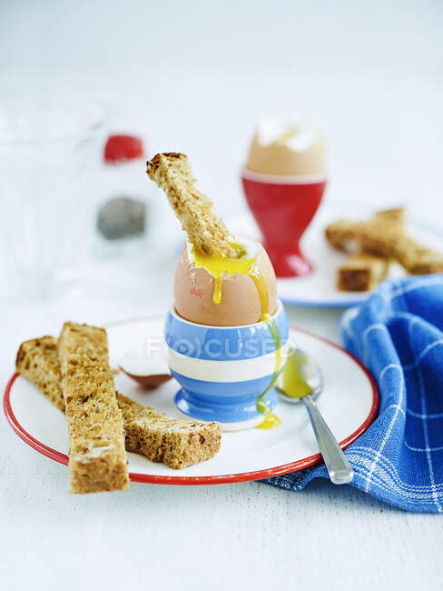 Huevo y soldados (un huevo suave con tiras de pan tostado, Inglaterra) - foto de stock