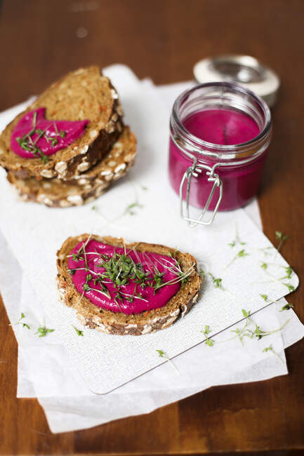 Wholemeal bread topped with a beetroot spread and cress — Stock Photo
